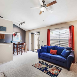living area open to dining area in model home with ceiling fan